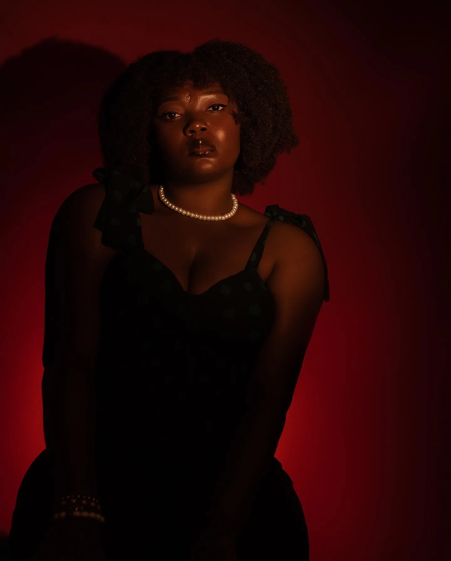 Gineve, in a red-lit studio portrait